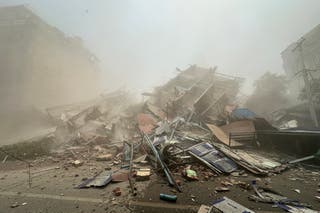 People inspect the debris of a collapsed building in Mandalay